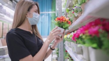Çekici bayan alıcı, indirimli bir rafta özel bir gün için hediye seçiyor, sarışın, uzun saçlı genç kadın yeni ev dekorasyonu malzemeleri buluyor, ev çiçekleri ve bitkiler, kişisel dekorasyon tarzı, ev dekorasyonu, hafta sonu aktiviteleri.