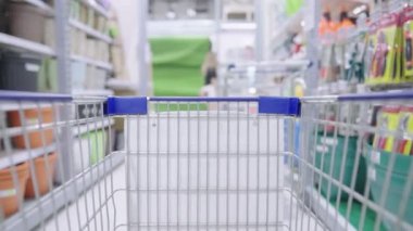 Süpermarket koridorunda hareket eden alışveriş arabasının POV 'u, nalbur dükkanının arka planına sahip alışveriş merkezinin tramvay şebekesi manzarası, hafta sonları dinlenme etkinliği, pazarlama tanıtımı veya indirimi, hafta sonu aktiviteleri, aylık giderlerin korunması