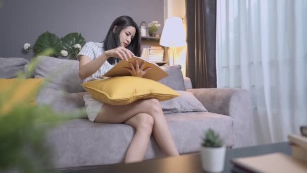Asiatisk Kvinnlig Avkopplande Läsning Litteratur Medan Sitter Soffan Helgen Förbättra — Stockvideo