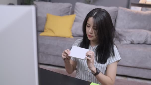 Молодая Женщина Записывает Идеи Блокнот Бумаги Затем Поделиться Экране Ноутбука — стоковое видео