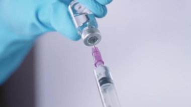 Elastik mavi koruyucu eldivenler iğneye sıvı aşı dolduruyor laboratuvar araştırmalarında biyoteknoloji, salgın salgını, pandemik tedavi, aşılanma, yakın çekim.