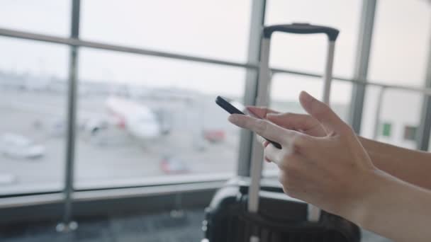 使用智能手机的人可以在机场候机楼在线等候 然后登机 预订机票 旅行箱 航空公司的飞机和飞机 — 图库视频影像