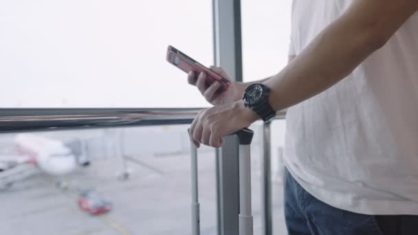 Junger Mann Steht Mit Smartphone Der Abflughalle Des Flughafenterminals Flugreise — Stockvideo