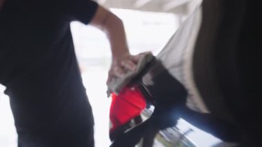 Erkek el ıslak havluyla araba parçasındaki tozu temizliyor. Arabanın arka lambası kirlenmiş yüzey, araba parlatıcısı, evde faaliyet, araç bakımı, yakın çekim yansıması, ticari kullanım için parlatıcı temizleme servisi