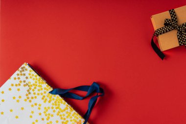 Kırmızı zemin üzerinde siyah altın kurdele olan hediye kutusu veya hediye kutusu.