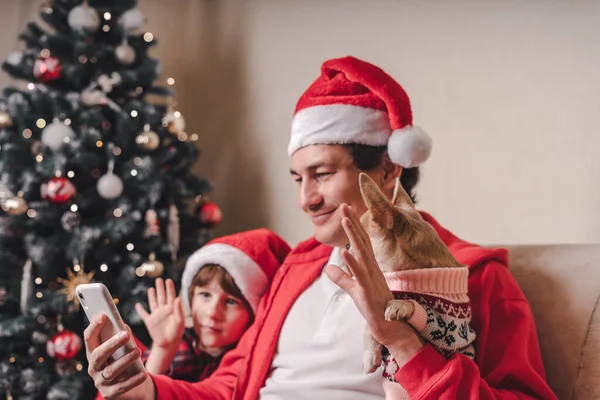 Otec Dítětem Štěně Pes Santa Klobouky Videohovor Štědrý Den Smartphone — Stock fotografie