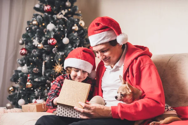 Ευτυχισμένη Οικογένεια Καπέλο Πατέρας Και Παιδί Ανοίγουν Χριστουγεννιάτικο Δώρο Στο — Φωτογραφία Αρχείου