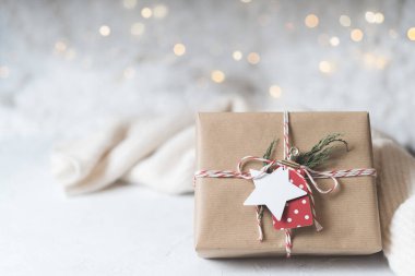 Noel hediyesi ve boş etiket. Işıl ışıl kar bokeh, kozalaklı dal. Kış tatilleri beyaz arka planda geçiyor. Sıfır atık, plastik yok