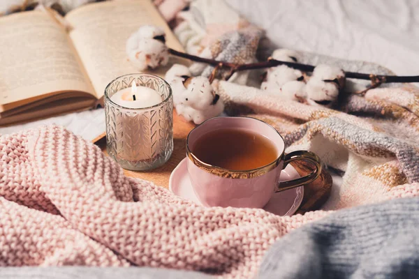 Taza de té, algodón, acogedor, libro, vela. Acogedor concepto de otoño invierno. — Foto de Stock