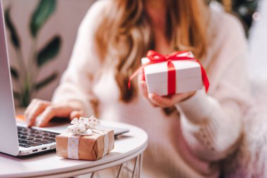 Dizüstü bilgisayarında hediye yazan bir kadın. Tatiller online alışveriş