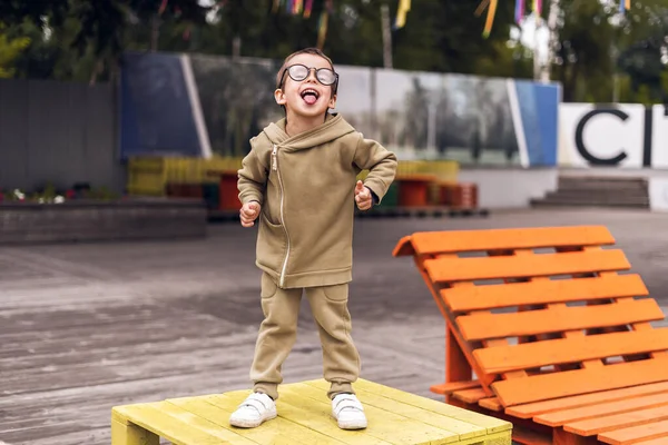 Vtipný úsměv smích dítě chlapec v kulaté brýle životní styl park portrét žák škola — Stock fotografie