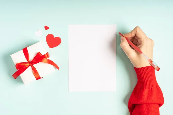 Piso laico de mano de mujer con carta maqueta y regalo de San Valentín. — Foto de Stock