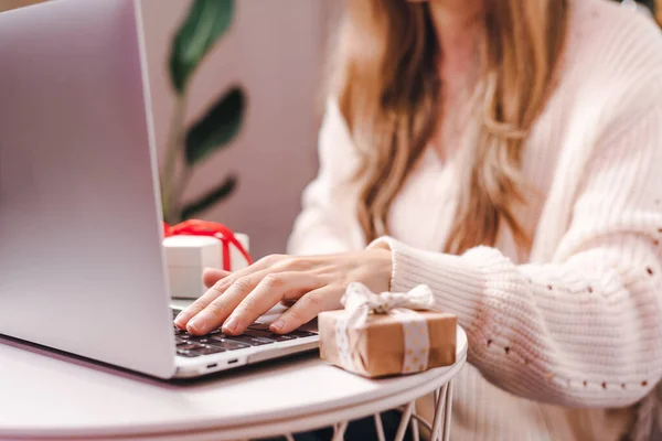 Mujer con el regalo escribiendo en el portátil. Vacaciones compras en línea — Foto de Stock