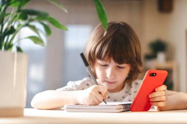 Okula dönelim. Evde telefonlu bir çocuk.