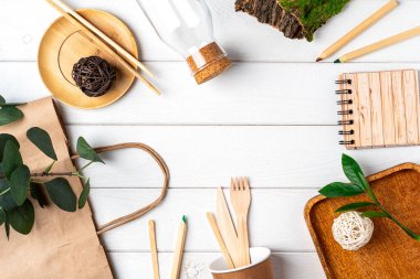 Eşya çantası, cam kavanoz, yeşil yapraklar ve geri dönüşümlü masa örtüsü manzarası. Sıfır atık, çevre dostu, doğal organik plastik konsept. Çatal bıçak takımı, toprak, kopyalama alanı ile ayrıştırılabilir.