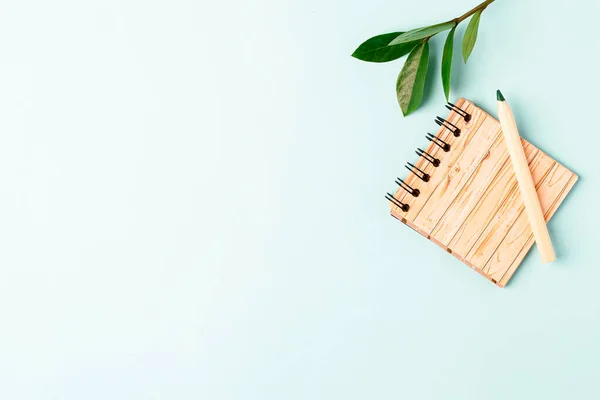 Volver a la pancarta de la escuela con lápiz y cuaderno. Material de oficina y papelería, fondo vacío de menta con espacio para texto. Concepto ecológico de cero residuos — Foto de Stock