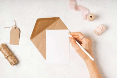 Elinde kağıt zarf olan boş bir beyaz kart.