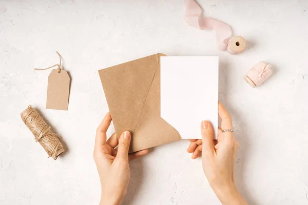 Prázdná bílá karta s papírovou obálkou v rukou — Stock fotografie