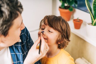 Babası çocuk çocuğun burnunu boyamış.