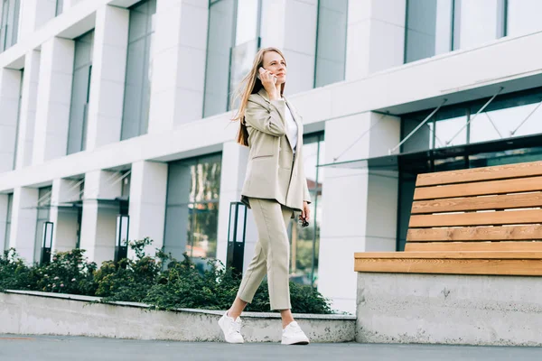 Hermosa mujer de negocios hablando por teléfono y caminando en la calle de la ciudad —  Fotos de Stock