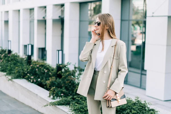 Hermosa mujer de negocios hablando por teléfono y caminando en la calle de la ciudad —  Fotos de Stock