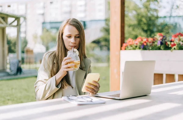 Güzel bir kadın cep telefonundan mesaj atıyor.