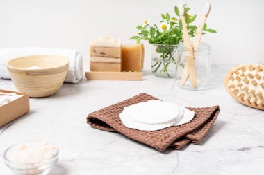 Doğal banyo ve spa aletleri. Sıfır sürdürülebilir yaşam tarzı konsepti. Bambu diş fırçası, doğal sabun, pamuk pedler, beyaz arka planda yeniden kullanılabilir şişelerde ev yapımı DIY güzellik ürünleri.