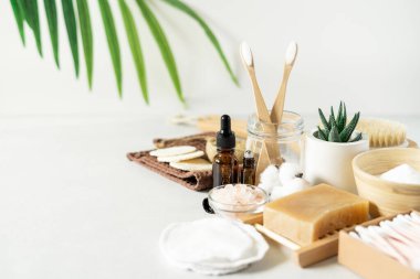 Doğal banyo ve spa aletleri. Sıfır sürdürülebilir yaşam tarzı konsepti. Bambu diş fırçası, doğal sabun, pamuk pedler, beyaz arka planda yeniden kullanılabilir şişelerde ev yapımı DIY güzellik ürünleri.