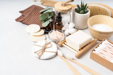Doğal banyo ve spa aletleri. Sıfır sürdürülebilir yaşam tarzı konsepti. Bambu diş fırçası, doğal sabun, pamuk pedler, beyaz arka planda yeniden kullanılabilir şişelerde ev yapımı DIY güzellik ürünleri.