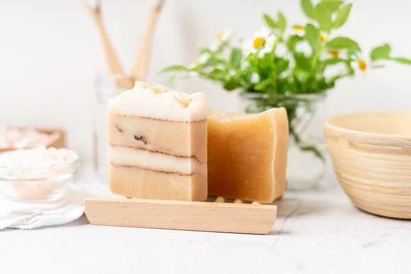 Bagno naturale e strumenti spa a casa. Zero rifiuti concetto di stile di vita sostenibile. Sapone naturale in portasapone in legno, tamponi di cotone e tamponi, fiori, spazzolino di bambù. Sfondo bianco, spazio di copia. — Foto Stock