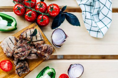 Et, sebze, domates, biber, soğan ve ahşap arka planda ızgarada kızartılmış fesleğen. Metin için kopyalama alanı olan düz uzandı.