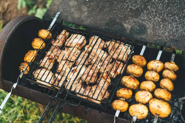 Grilování s masem a houbami smažené na grilu venku na dvorku. Houby na špejlích jsou smažené na dřevěném uhlí — Stock fotografie