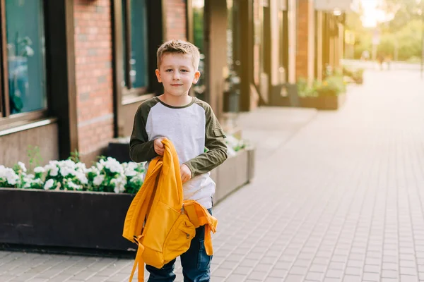 De volta à escola. Mochila infantil bonito embalagem, segurando bloco de notas e livros de treinamento indo para a escola. Aluno com saco. Estudante da escola primária a ir às aulas. Criança andando ao ar livre na rua da cidade — Fotografia de Stock