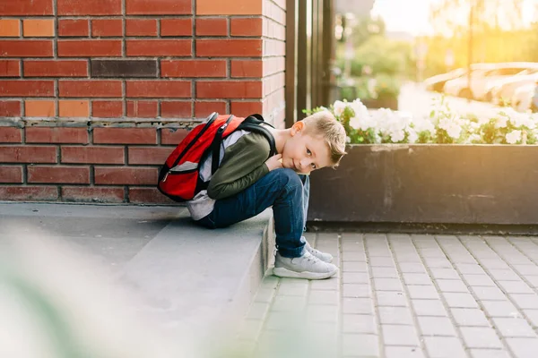 Zpátky do školy. Roztomilé dítě s batohem, zápisníkem a učebnicemi. Školní žák s taškou. Student základní školy chodí na hodiny. Dítě sedící venku na schodech u cihlové zdi — Stock fotografie