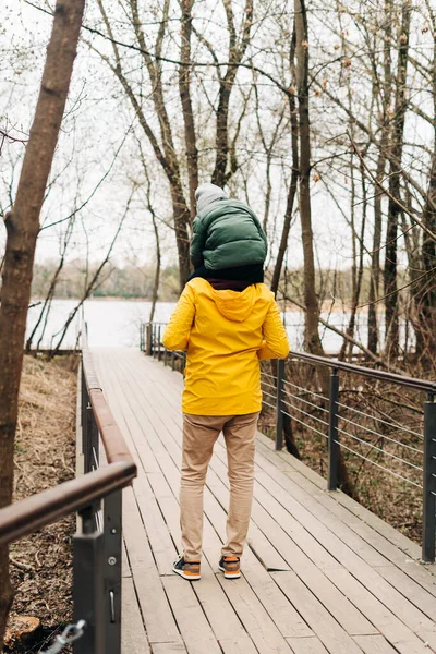 Padre e hijo divirtiéndose con paseo a caballo en el bosque. Familia feliz con niño niño niño jugando y divirtiéndose al aire libre sobre fondo del parque de otoño —  Fotos de Stock