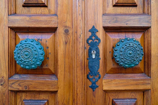 Ornamental decorative bronze door knobs on closed doors.