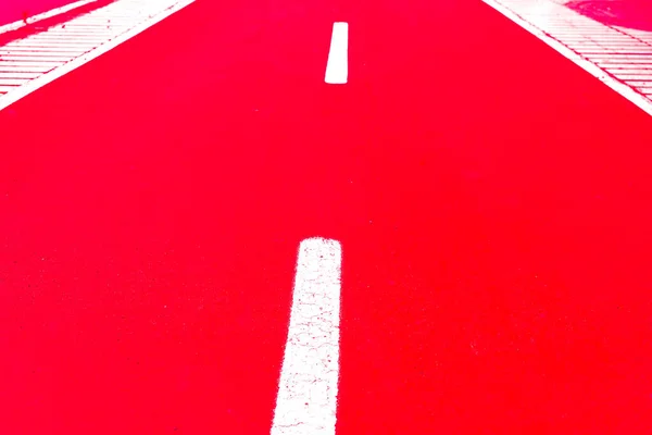 White dashed line limiting bike lanes, painted with luminescent paint, bike road markings, flash gun artificial light.