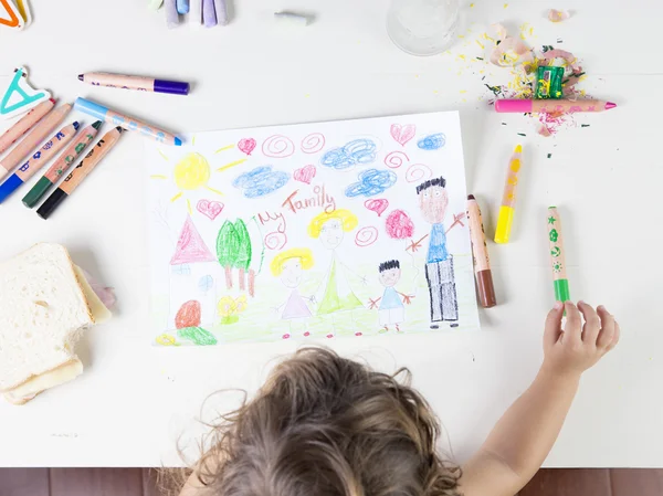 Niña eligiendo un lápiz de color verde en una mesa de madera para — Foto de Stock