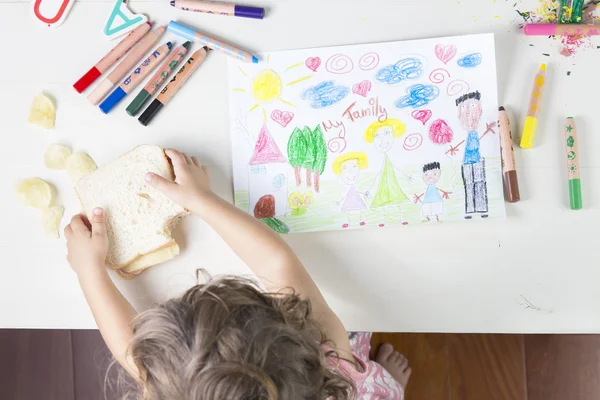 Little girl catching a sandwich after finishing her family drawi — Stock Photo, Image