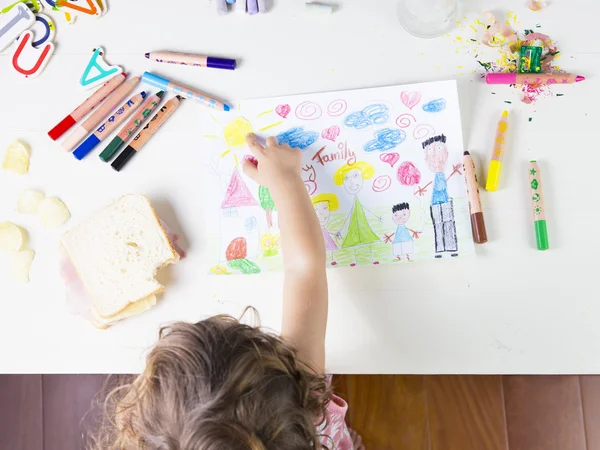 Маленькая девочка указывает на солнце в детском рисунке многорасовой семьи — стоковое фото