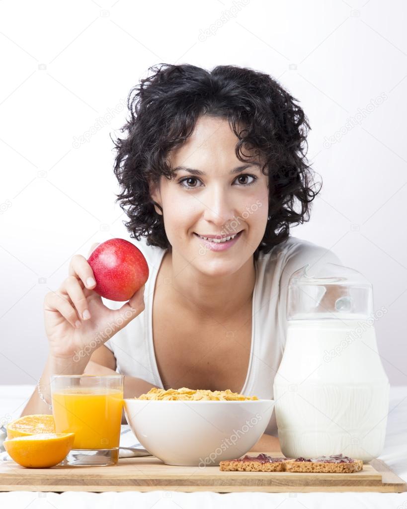 Woman with an apple to a healthy breakfast on white background
