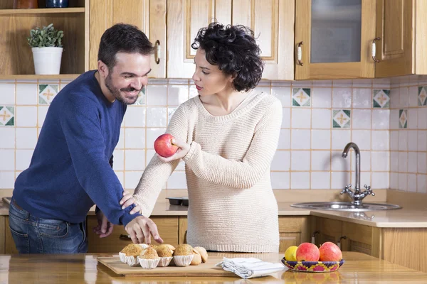 Man taking delicious cupcake while her woman offering him an app — Stock Photo, Image