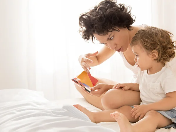 Vrouw en baby meisje lezen op bed — Stockfoto