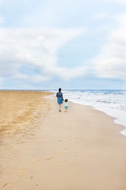 Anne ve kızı ayak izleri ile Sahilde yürüyüş hakkında otantik fotoğraf