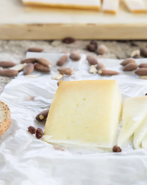 Gros plan de morceaux de fromage et d'amandes grillées sur une table en pierre — Photo