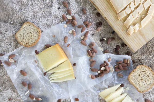 Variété de fromages, amandes grillées, toasts sur table en pierre — Photo