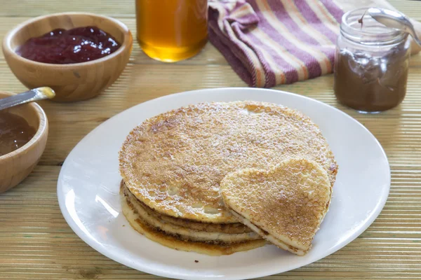 Me encantan los panqueques. Panqueque en forma de corazón con mermelada de fresa en una pila de panqueques —  Fotos de Stock