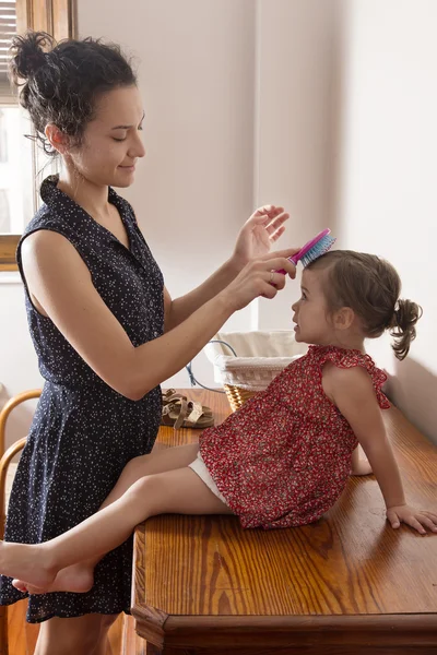 Mother combing the hair of her daughter — Stock Photo, Image