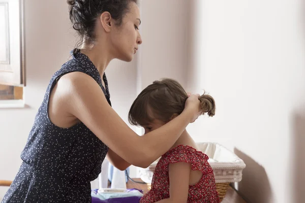 Mutter kämmt die Haare ihrer Tochter — Stockfoto