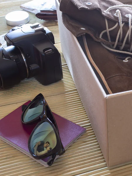 Open box with a pair of boots. Couple giving a kiss to an adventure trip — Stock Photo, Image